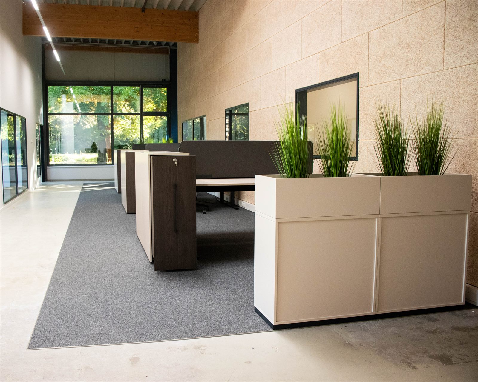 Arbeitsplätze mit Pflanzkübeln in einer hellen Halle